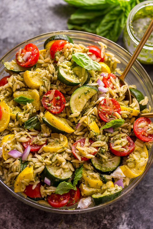It's beginning to feel a lot like Summer, and you know what that means, right? It's PASTA SALAD SEASON! And this Pesto Orzo Pasta Salad with Zucchini, Goat Cheese, and Tomatoes is sure to be on heavy rotation all Summer long! This mayo-free pasta salad is vegetarian friendly and perfect for picnics, potlucks, and barbecues! #pestopastasalad #pesto #orzo #orzopastasalad