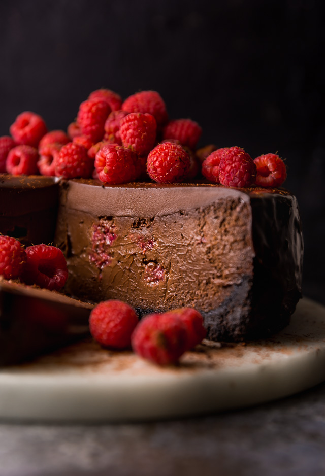 This Dark Chocolate Raspberry Cheesecake is pure decadence! It's not too sweet and but very rich, so a small slice goes far! The fresh raspberry pockets swirled throughout are delightfully refreshing! #chocolateraspberrycheesecake #chocolate #raspberry #raspberrycheesecake #cheesecake #Chocolatecheesecake #dessertrecipes