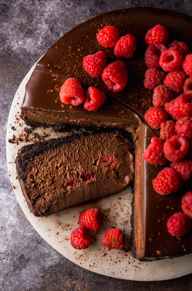 This Dark Chocolate Raspberry Cheesecake is pure decadence! It's not too sweet and but very rich, so a small slice goes far! The fresh raspberry pockets swirled throughout are delightfully refreshing! #chocolateraspberrycheesecake #chocolate #raspberry #raspberrycheesecake #cheesecake #Chocolatecheesecake #dessertrecipes