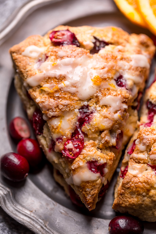 Plate of cranberry orange scones with orange glaze on top.
