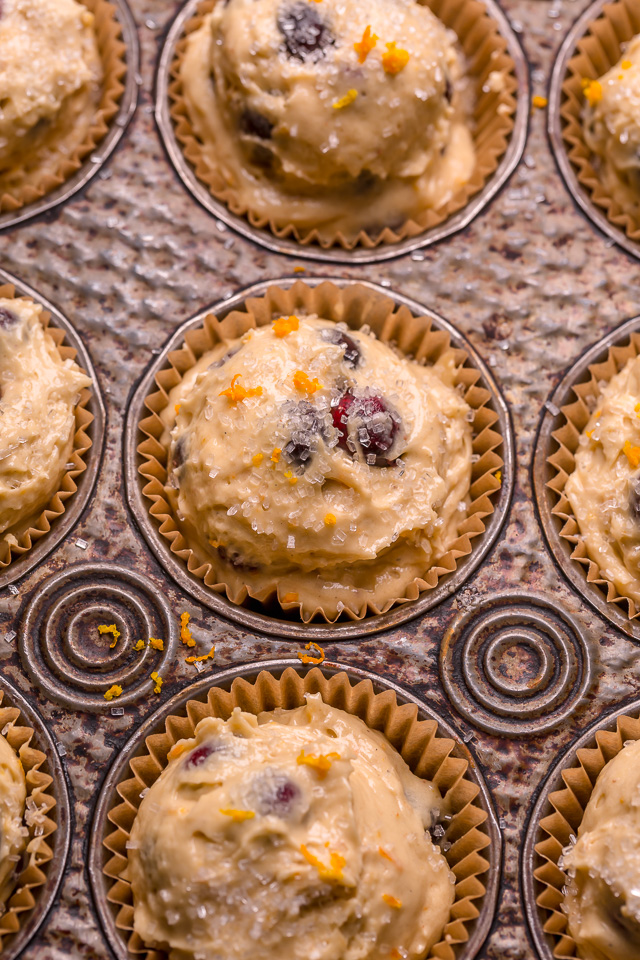 Muffin batter in a muffin pan for cranberry orange muffins.