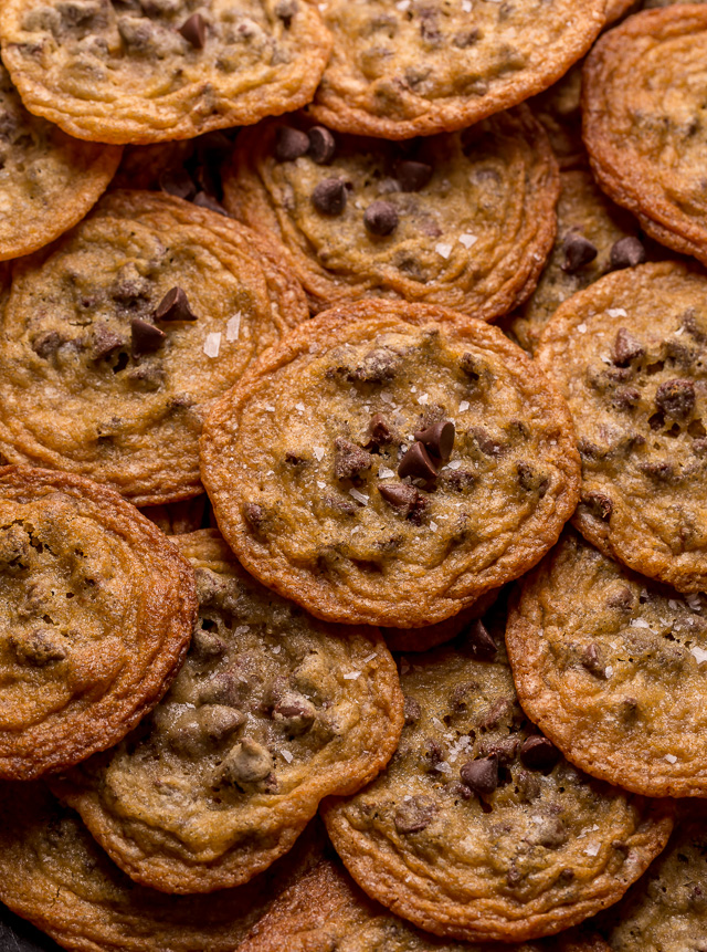 Pile of crispy chocolate chips with extra chocolate chips and sea salt on top.