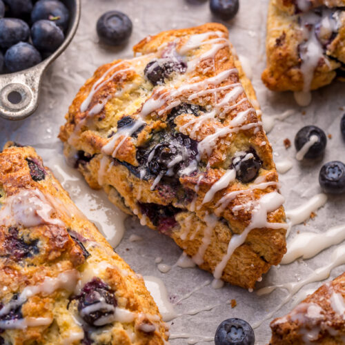 Blueberry scone recipe with vanilla glaze on baking sheet