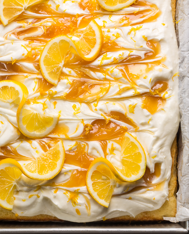 My lemon cake for a crowd is moist, fluffy, and loaded with fresh lemon flavor! Topped with silky smooth lemon cream cheese frosting, dollops of lemon curd, and fresh lemon slices, this is one of my most popular lemon desserts. Bonus: this lemon sheet cake is so easy and feeds a crowd!