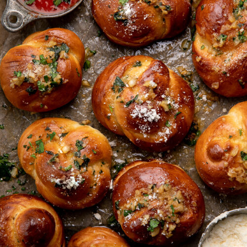 Soft Pretzel Garlic Knots are chewy, flavorful, and so delicious! Made with a simple soft pretzel dough, they're shaped like knots and baked until golden brown. Then topped with garlic butter and parmesan cheese!