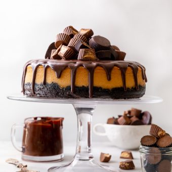 This Chocolate Covered Peanut Butter Cheesecake is ultra creamy and the perfect marriage of chocolate and peanut butter! Featuring an oreo crust, creamy peanut butter cheesecake filling, and topped with with peanut butter chocolate ganache and peanut butter cups, it's a true showstopper! And any leftovers freeze great!