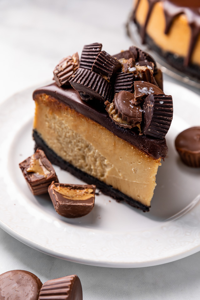 This Chocolate Covered Peanut Butter Cheesecake is ultra creamy and the perfect marriage of chocolate and peanut butter! Featuring an oreo crust, creamy peanut butter cheesecake filling, and topped with with peanut butter chocolate ganache and peanut butter cups, it's a true showstopper! And any leftovers freeze great!