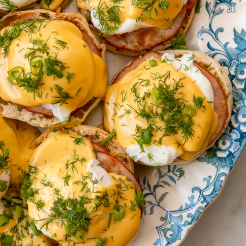 Featuring golden brown toasted English muffins, poached eggs, slices of Canadian bacon, and hollandaise sauce, this Eggs Benedict recipe is pure perfection! Top with freshly chopped dill and scallions, or simply serve with salt and pepper. Perfect for any special at-home breakfast or brunch!