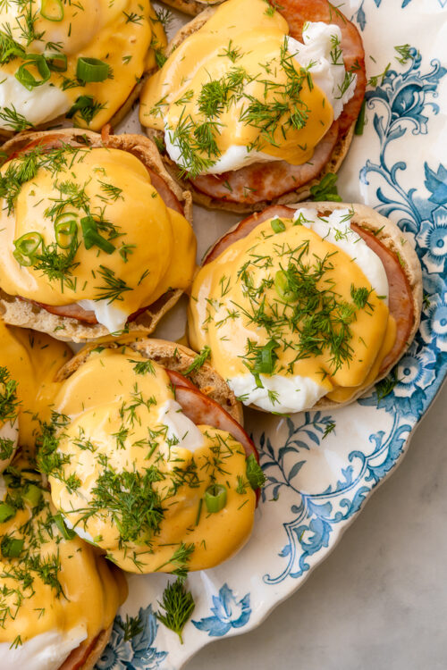 Featuring golden brown toasted English muffins, poached eggs, slices of Canadian bacon, and hollandaise sauce, this Eggs Benedict recipe is pure perfection! Top with freshly chopped dill and scallions, or simply serve with salt and pepper. Perfect for any special at-home breakfast or brunch!