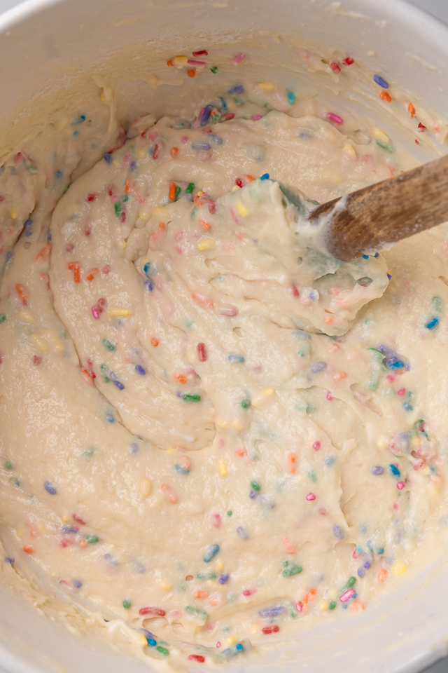 Funfetti cake batter in a large mixing bowl with a spatula.