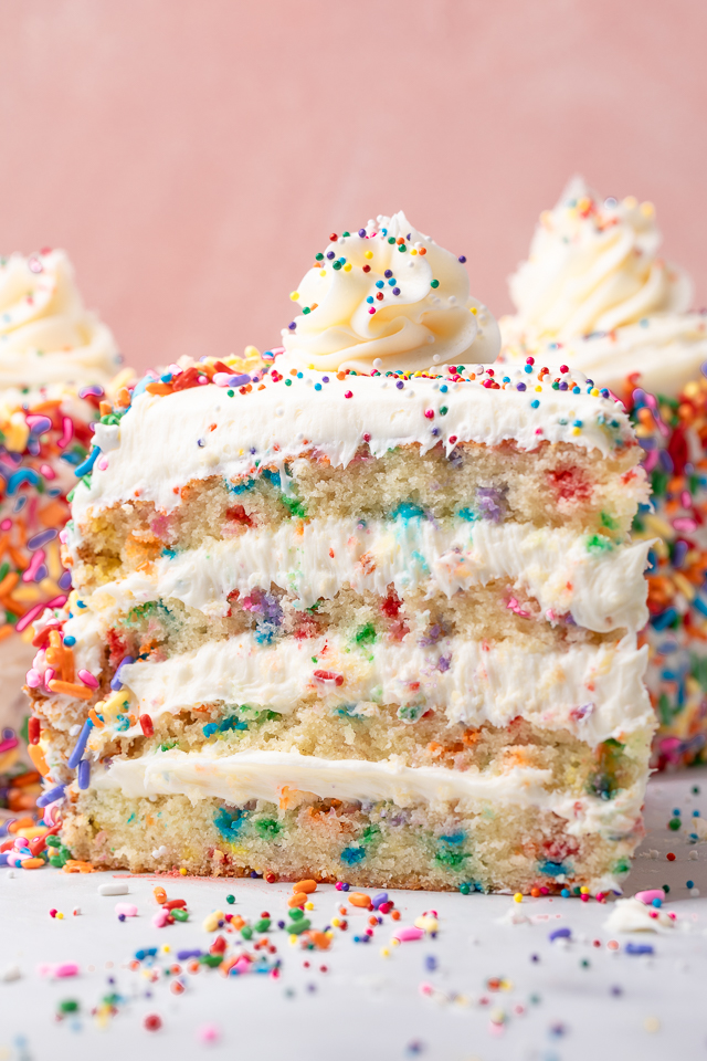 Slice of funfetti cake on a piece of parchment paper.