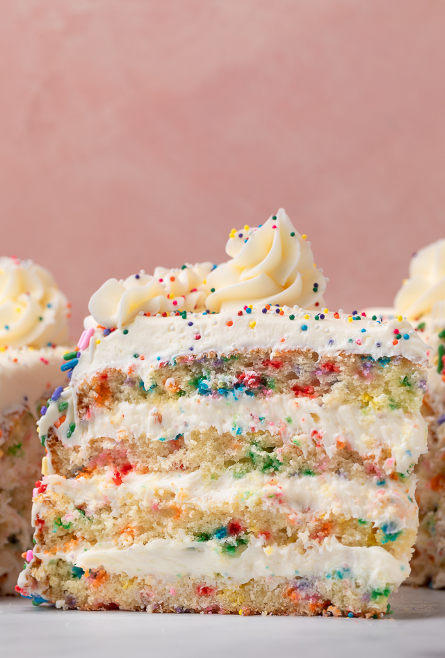 Slice of funfetti cake on a piece of parchment paper.
