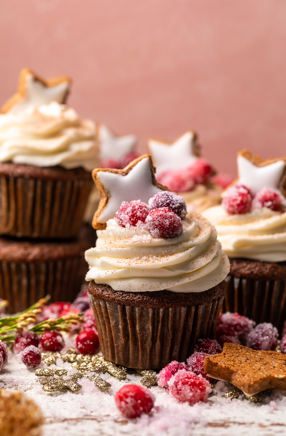 Gingerbread cupcakes in paper liners topped with Mascarpone Frosting and Maple Candied Cranberries!