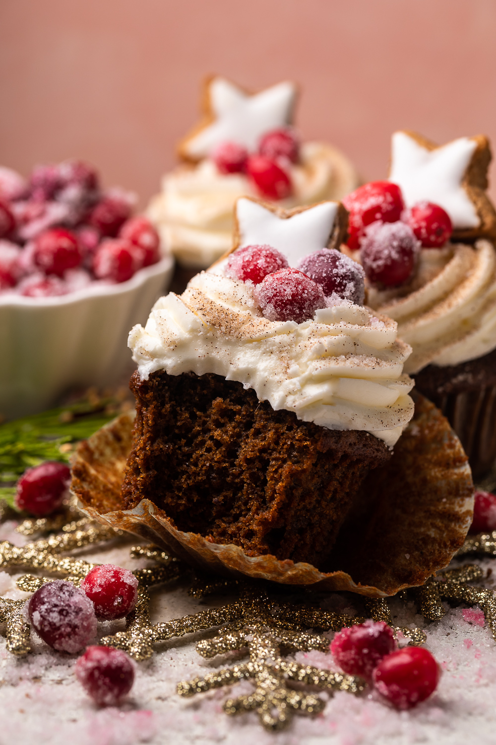Gingerbread cupcakes topped with cream cheese Frosting with a bite taken out.