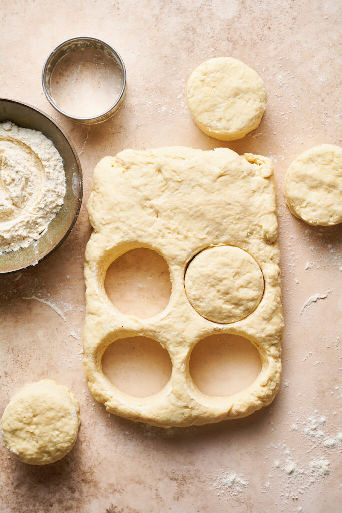 Buttermilk biscuit dough being cut into circles.