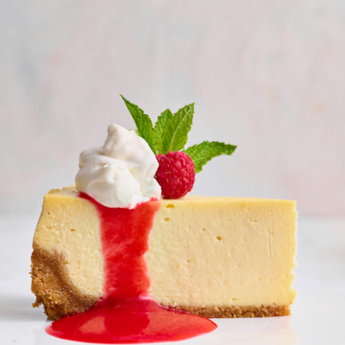 This stunning lemon ginger cheesecake is rich, cream, and silky smooth! Made with fresh ginger, lemon juice, and lemon zest, it's bursting with fresh flavor. The hot pink raspberry sauce makes it a total showstopper!