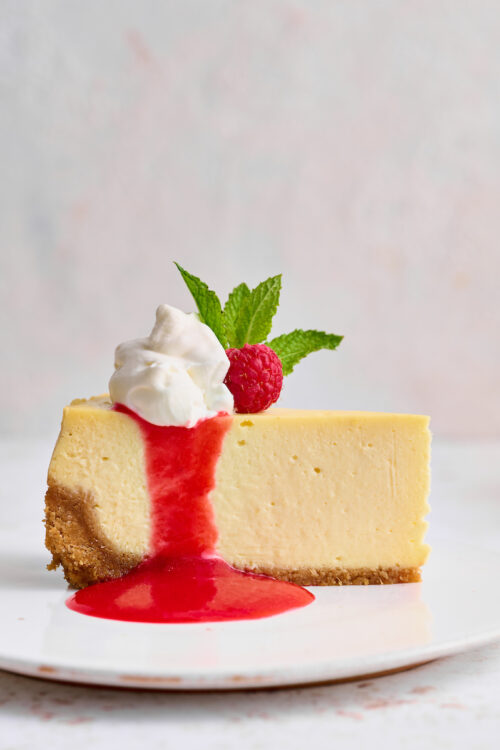 This stunning lemon ginger cheesecake is rich, cream, and silky smooth! Made with fresh ginger, lemon juice, and lemon zest, it's bursting with fresh flavor. The hot pink raspberry sauce makes it a total showstopper!