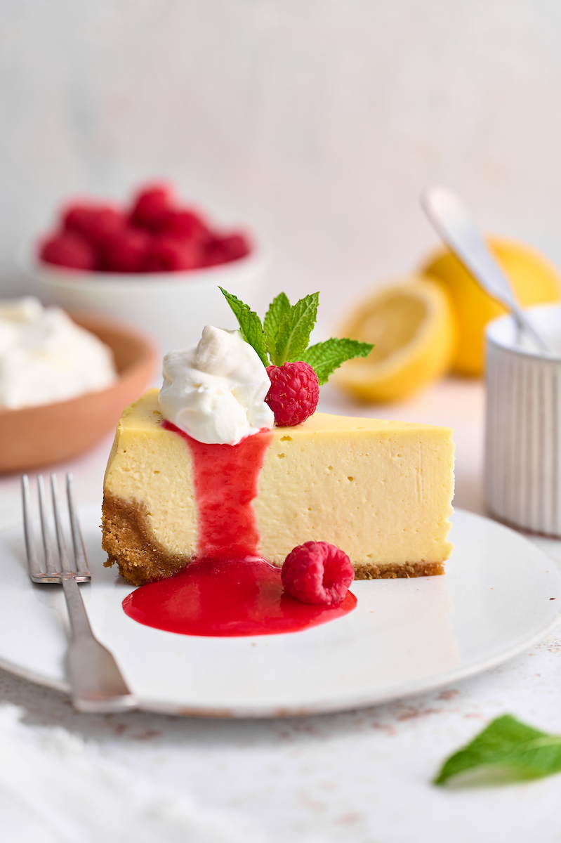 This stunning lemon ginger cheesecake is rich, cream, and silky smooth! Made with fresh ginger, lemon juice, and lemon zest, it's bursting with fresh flavor. The hot pink raspberry sauce makes it a total showstopper!