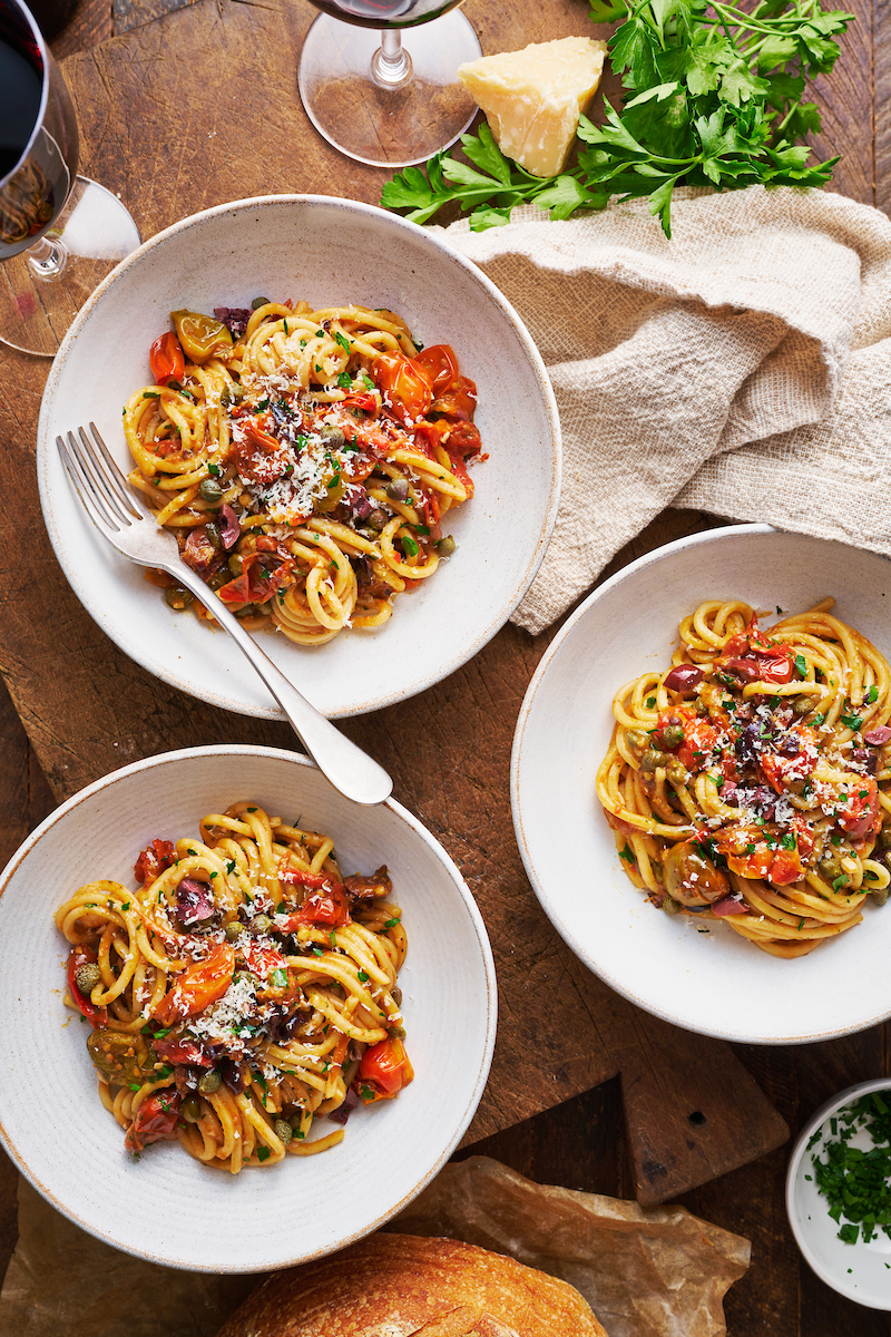 If you're looking for some dinner inspiration, allow me to tempt you with this fresh tomato pasta puttanesca. The tomato based puttanesca sauce is made from pantry staples like anchovy fillets, capers, and black olives. And it gets tossed with al dente pasta (any variety will work) for a classic Italian pasta dish the whole family will enjoy!