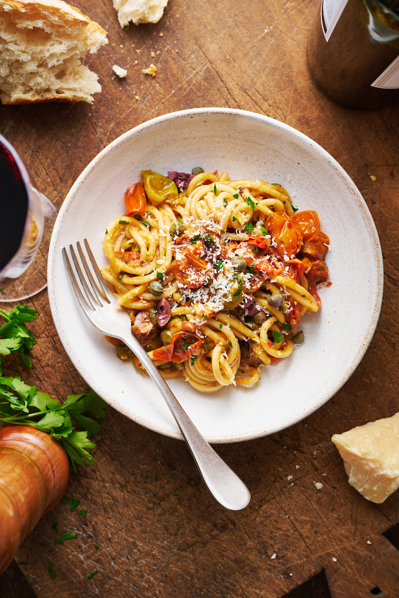 If you're looking for some dinner inspiration, allow me to tempt you with this fresh tomato pasta puttanesca. The tomato based puttanesca sauce is made from pantry staples like anchovy fillets, capers, and black olives. And it gets tossed with al dente pasta (any variety will work) for a classic Italian pasta dish the whole family will enjoy!