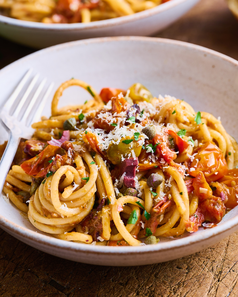 If you're looking for some dinner inspiration, allow me to tempt you with this fresh tomato pasta puttanesca. The tomato based puttanesca sauce is made from pantry staples like anchovy fillets, capers, and black olives. And it gets tossed with al dente pasta (any variety will work) for a classic Italian pasta dish the whole family will enjoy!