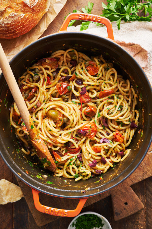 If you're looking for some dinner inspiration, allow me to tempt you with this fresh tomato pasta puttanesca. The tomato based puttanesca sauce is made from pantry staples like anchovy fillets, capers, and black olives. And it gets tossed with al dente pasta (any variety will work) for a classic Italian pasta dish the whole family will enjoy!