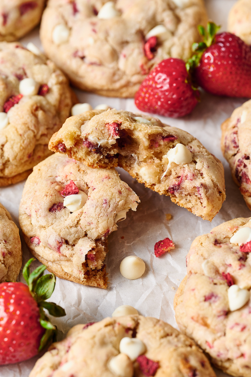 Strawberry cookie broken in half on a baking sheet.