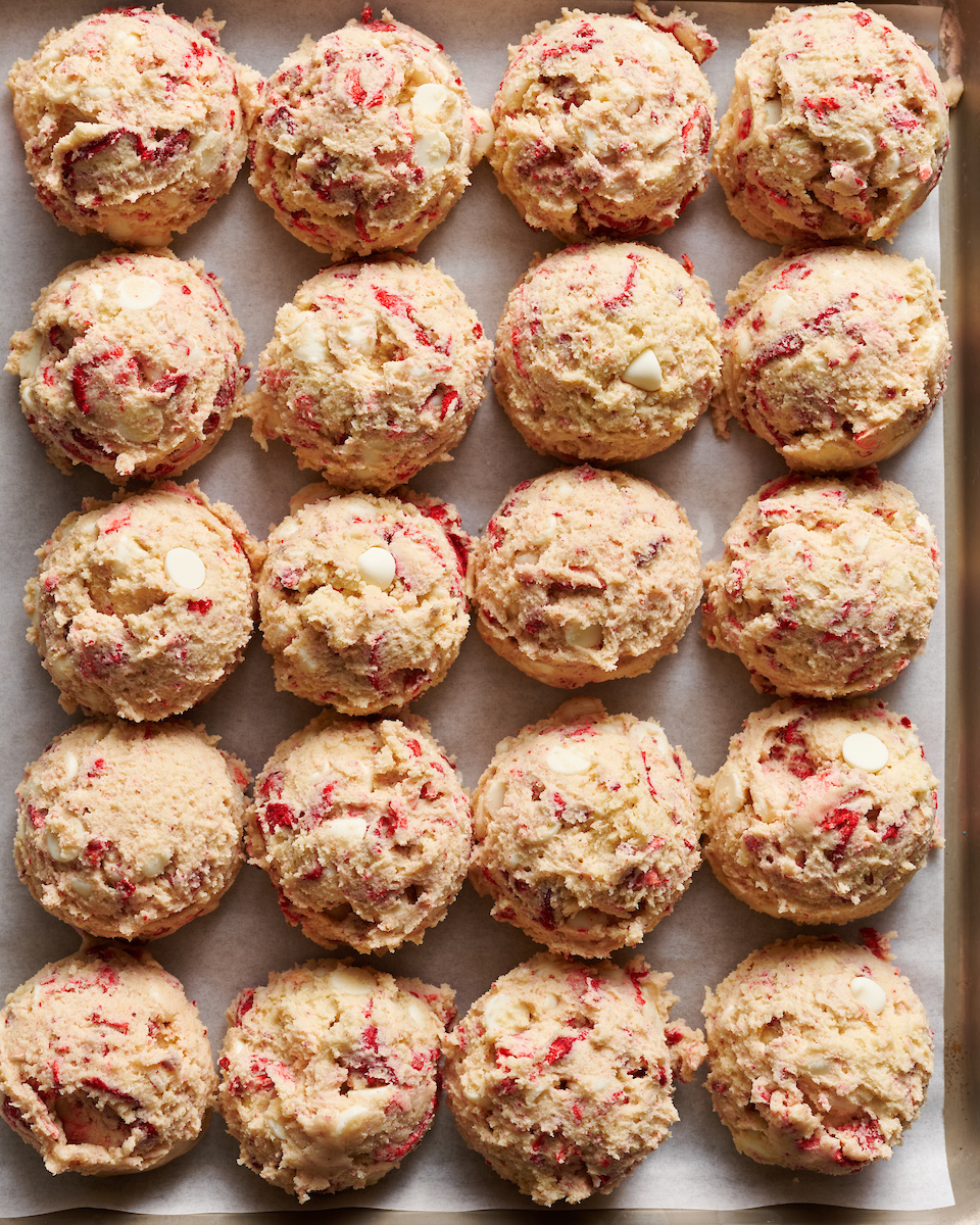 Strawberry cookie dough scooped onto a cookie sheet.