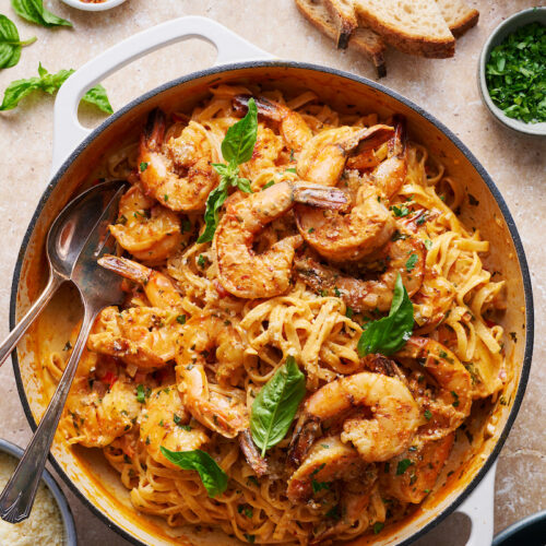 Cajun shrimp pasta topped with juicy shrimp and fresh herbs, served in a white dutch-oven.