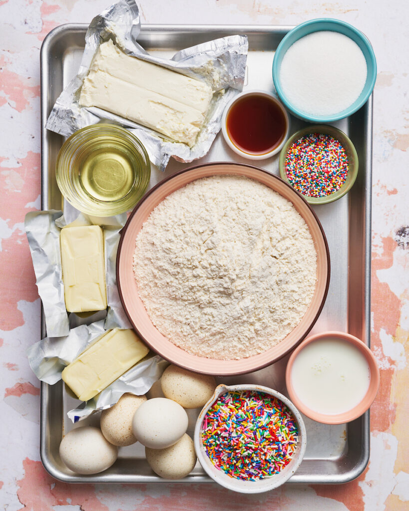 Ingredients for funfetti cake on a baking sheet.