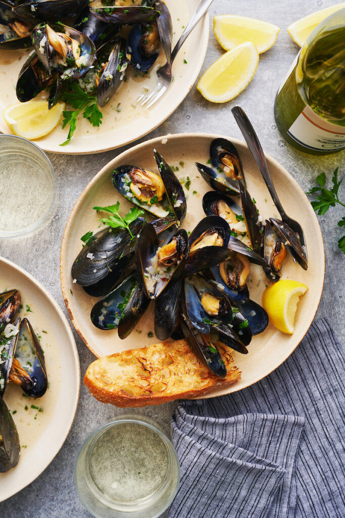 Mussels in shallow bowls served with white wine sauce.