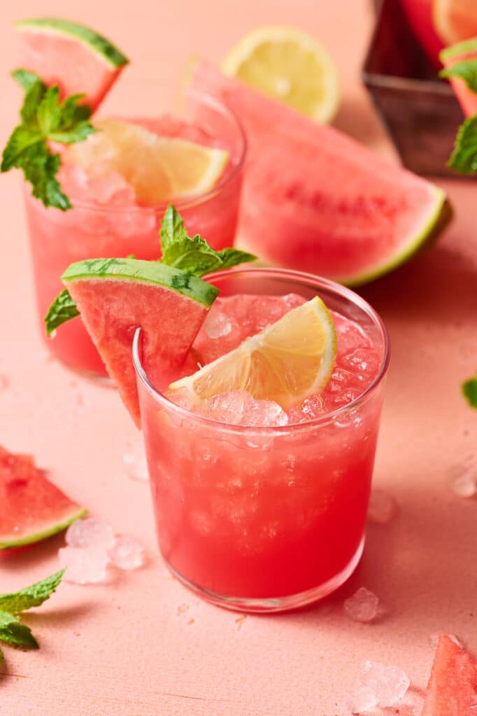 Watermelon lemonade in a small glass with mint and watermelon wedges.