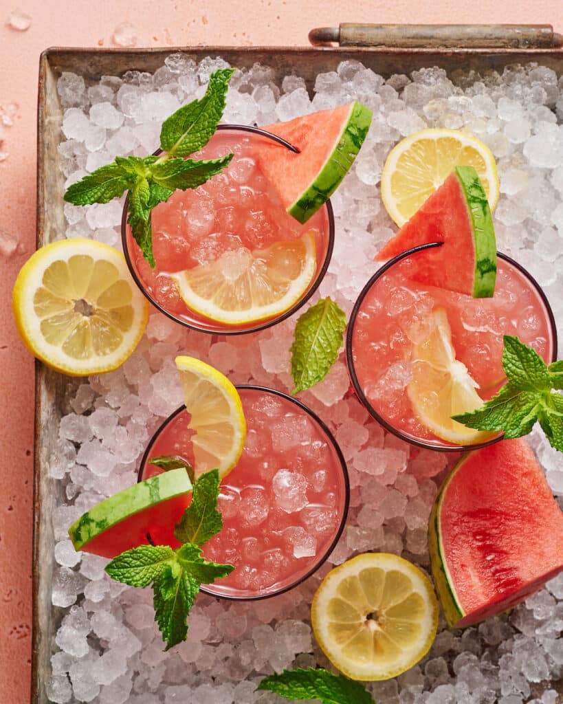 Tray of ice and overhead view of watermelon lemonade in cups.