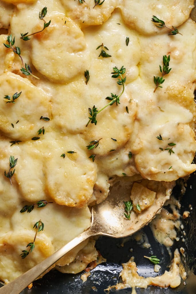 Casserole dish with creamy scalloped potatoes in it.