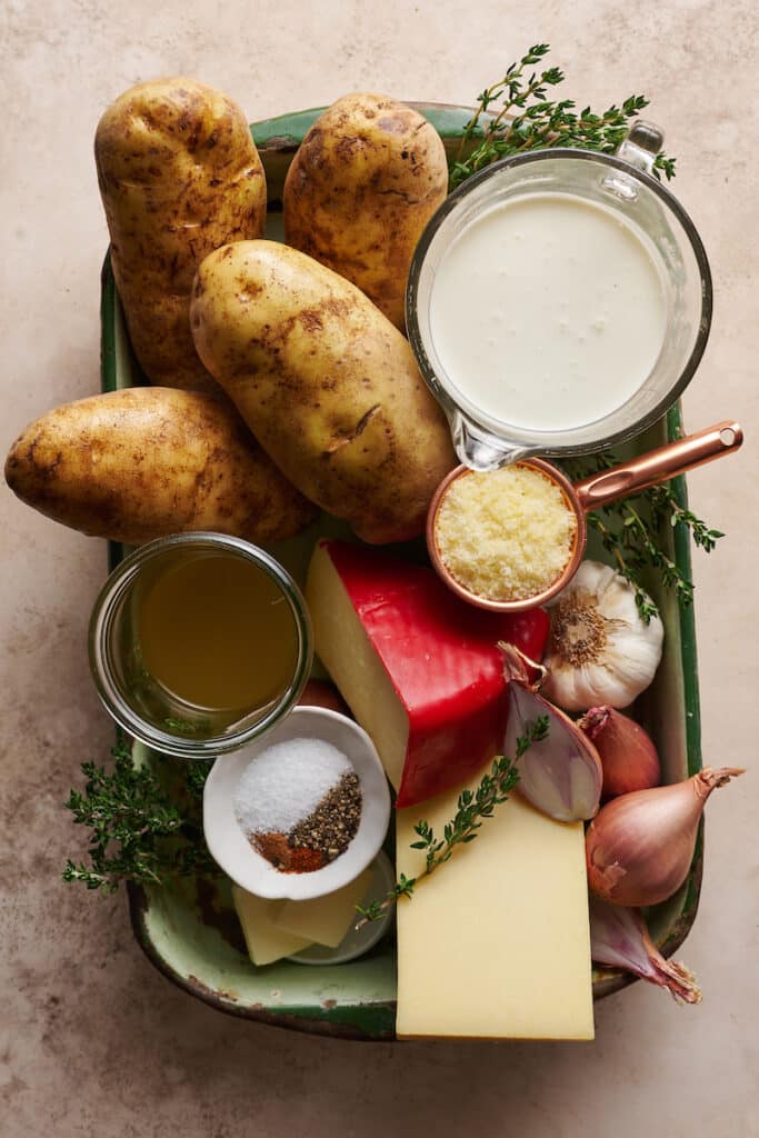 Ingredients for scalloped potatoes on a baking sheet.