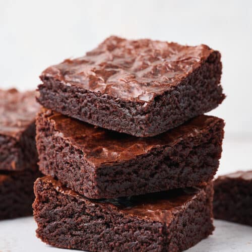 A stack of small batch brownies on a white table.