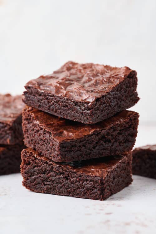 A stack of small batch brownies on a white table.