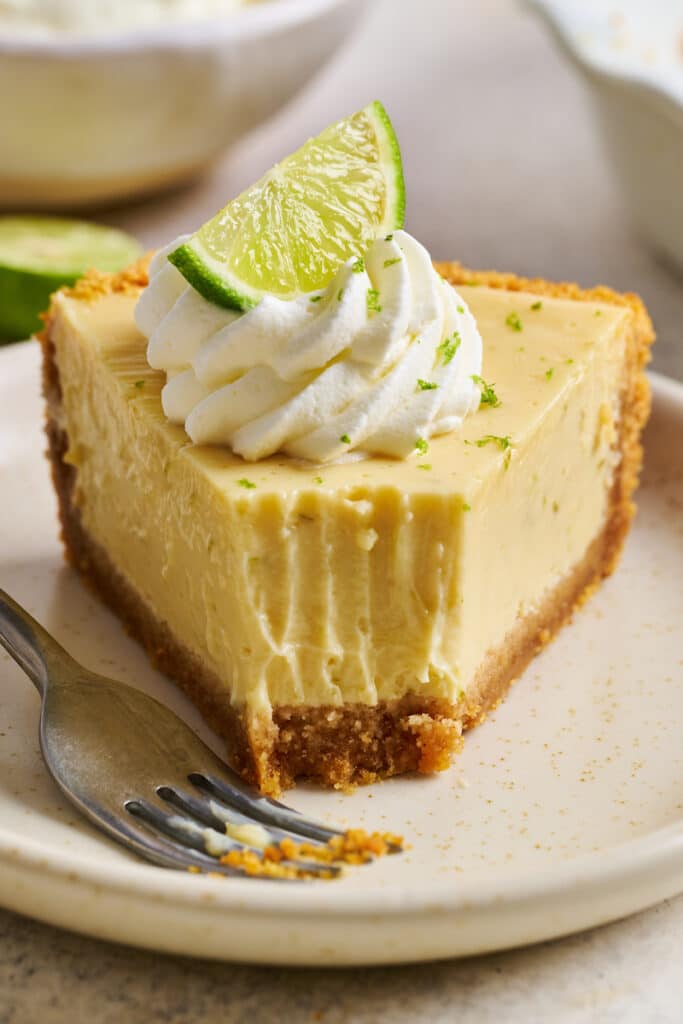Slice of key lime pie with a bite taken out.