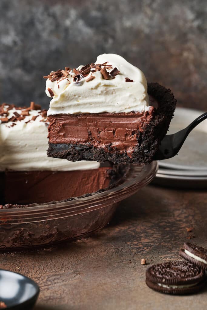 Slice of chocolate cream being being removed from the pie plate.