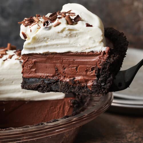 Egg free dessert featuring a chocolate cream pie being lifted out of the pie plate.