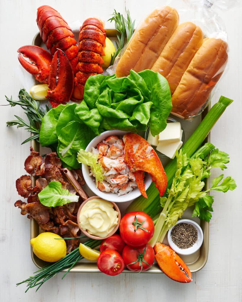 Ingredients for lobster rolls including cooked lobster meat and split top buns