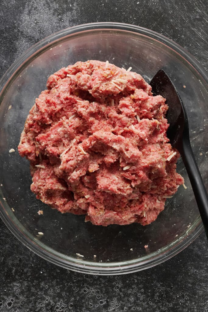 Meatball mix in a glass bowl.