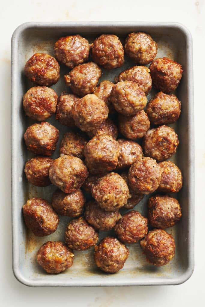 Mini meatballs on a baking sheet.