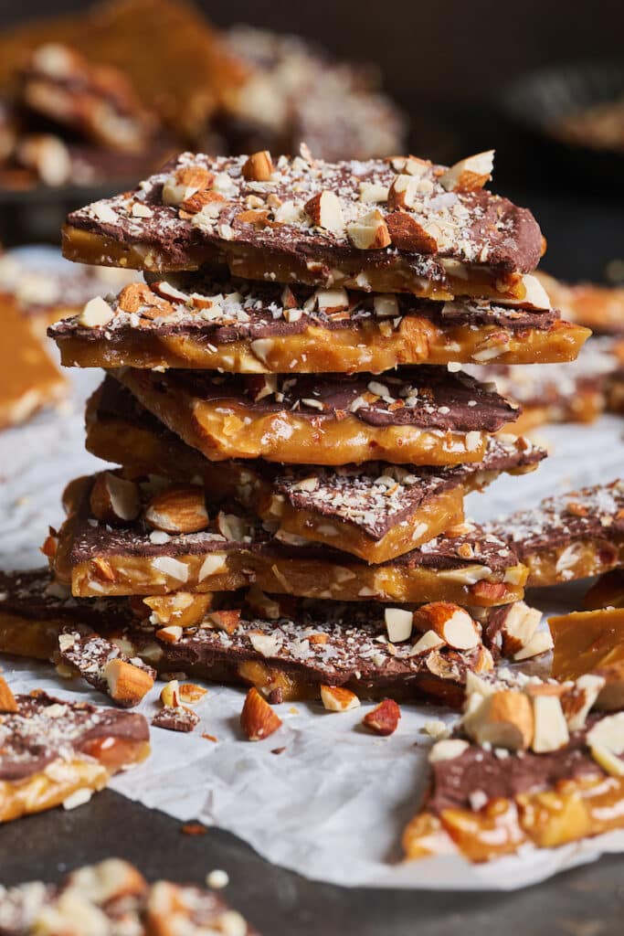 Stack of homemade toffee on parchment paper.
