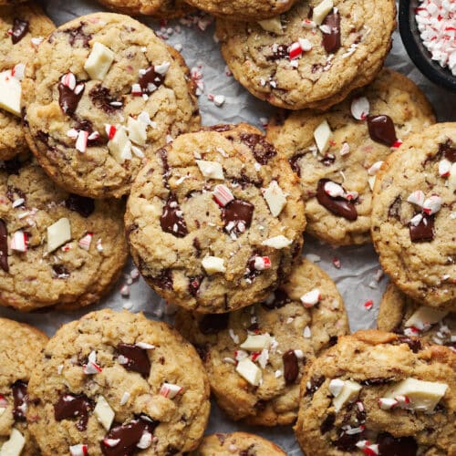 A tray of chocolate chip candy cane cookies with extra chocolate chunks on top.