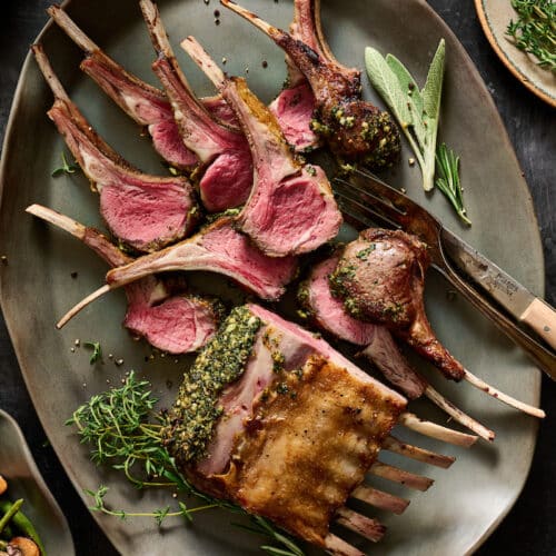 Rack of lamb cooked medium rare and sliced into lamb chops.