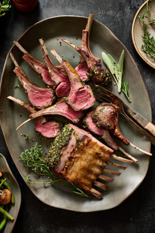 Rack of lamb cooked medium rare and sliced into lamb chops.